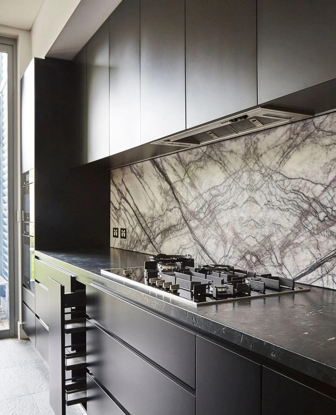 Black Kitchen With Marble Backsplash